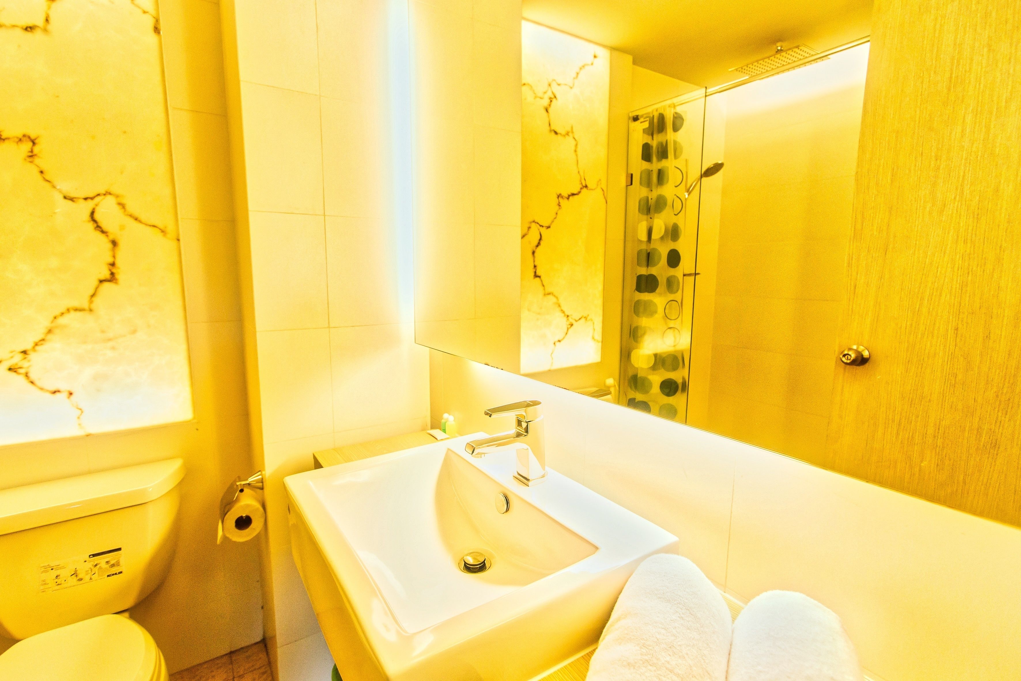 A bathroom with a white sink, a toilet, and a mirror.