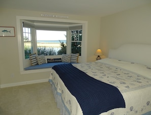 A bedroom with a large bed, a window seat with a view of the beach, and a sign indicating the location as 'Chatham'. - Chatham's Best Views-Harbor & Atlantic; On the Beach 4 Kayaks, 2 SUP's, 5 chairs (North Chatham)