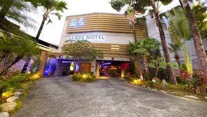 The exterior of the Li-Gin Motel with a modern design, featuring a prominent entrance and lush landscaping.