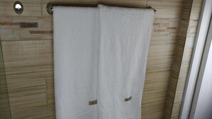 Un baño con una toalla colgada en un tendedero de metal.