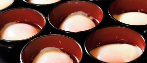 Une vue rapprochée de plusieurs gobelets rouges contenant une substance blanche, qui pourrait être un dessert ou une boisson.