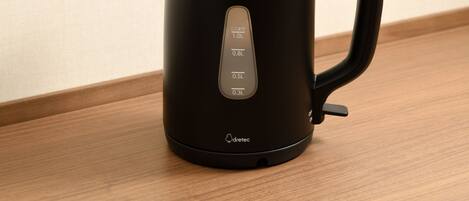 A black electric kettle with a digital display on a wooden surface.