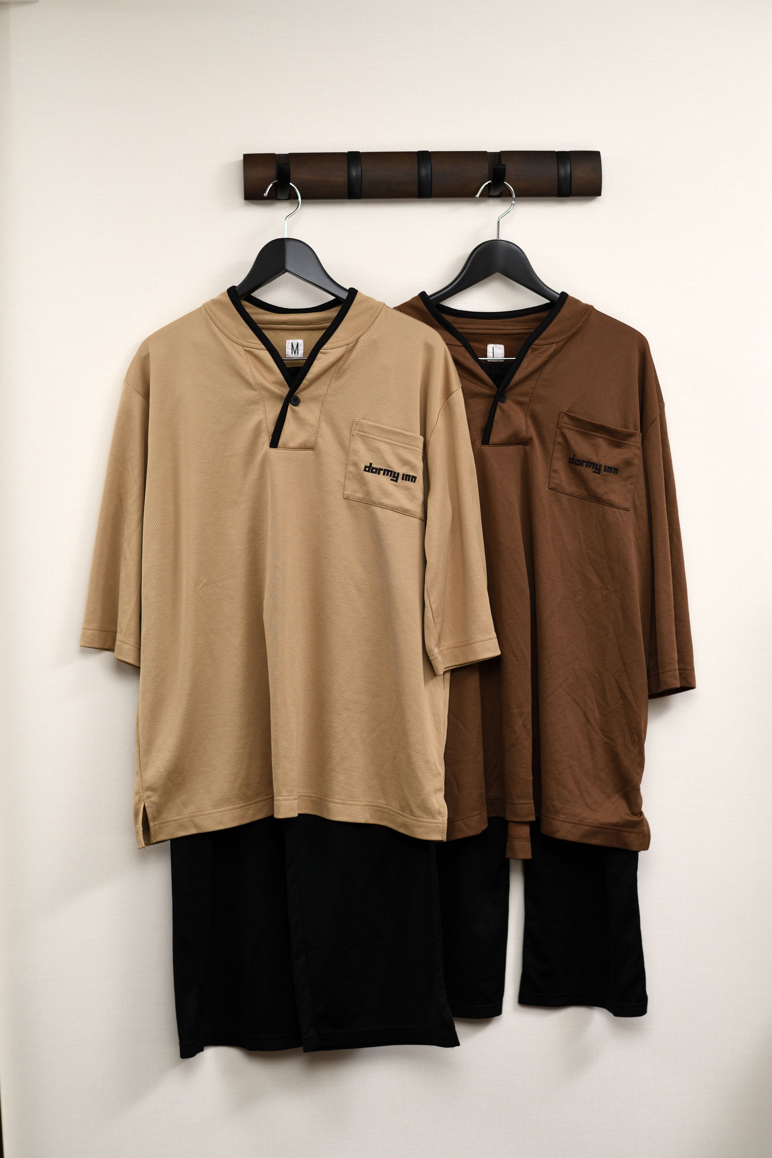 Two long-sleeved tops hanging on a rack.