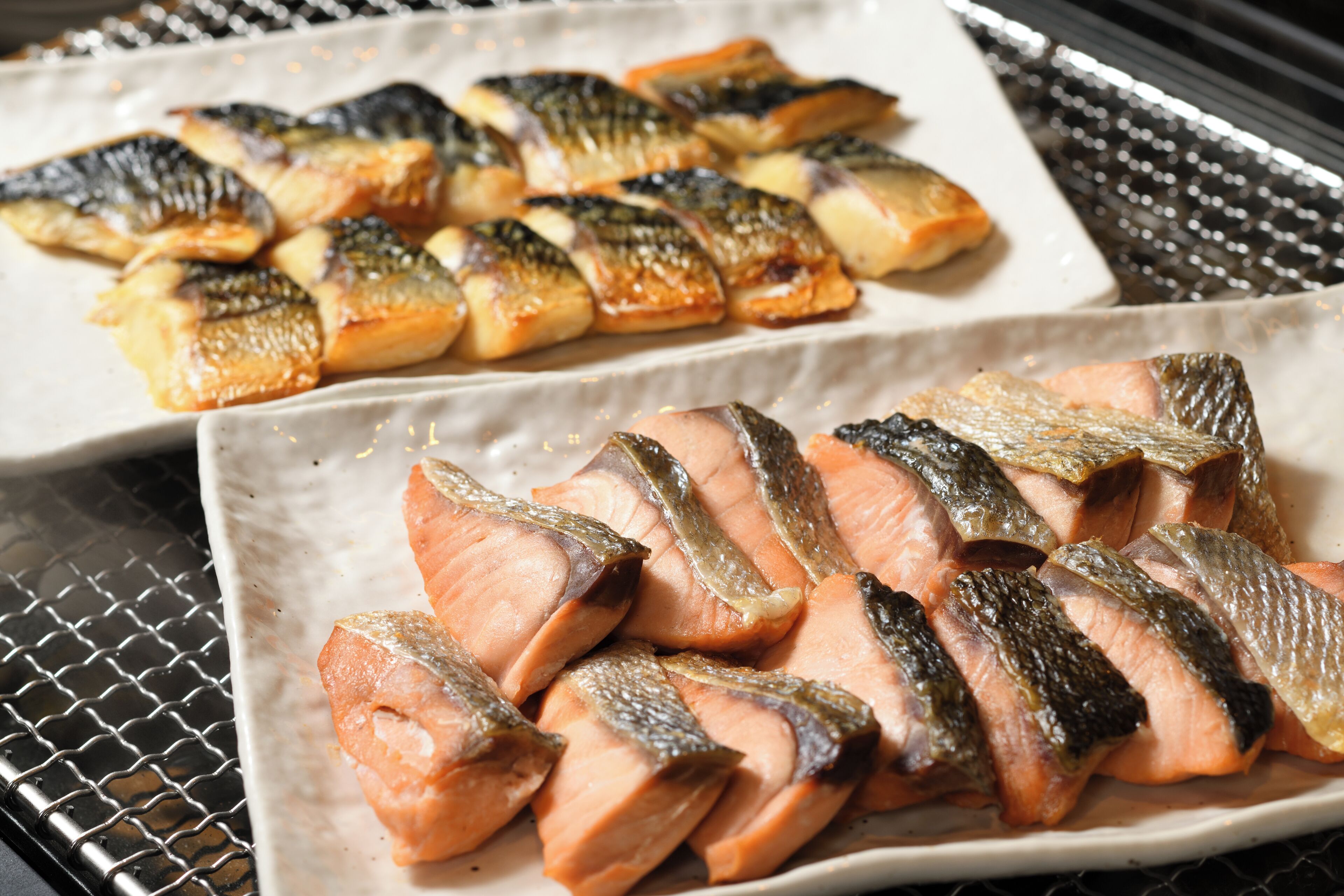 Un plato de pescado cocido, probablemente salmón, dispuesto ordenadamente sobre un plato blanco.