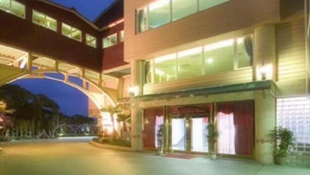 Un hotel de dos pisos, con un acceso cubierto y un espacio exterior bien iluminado.