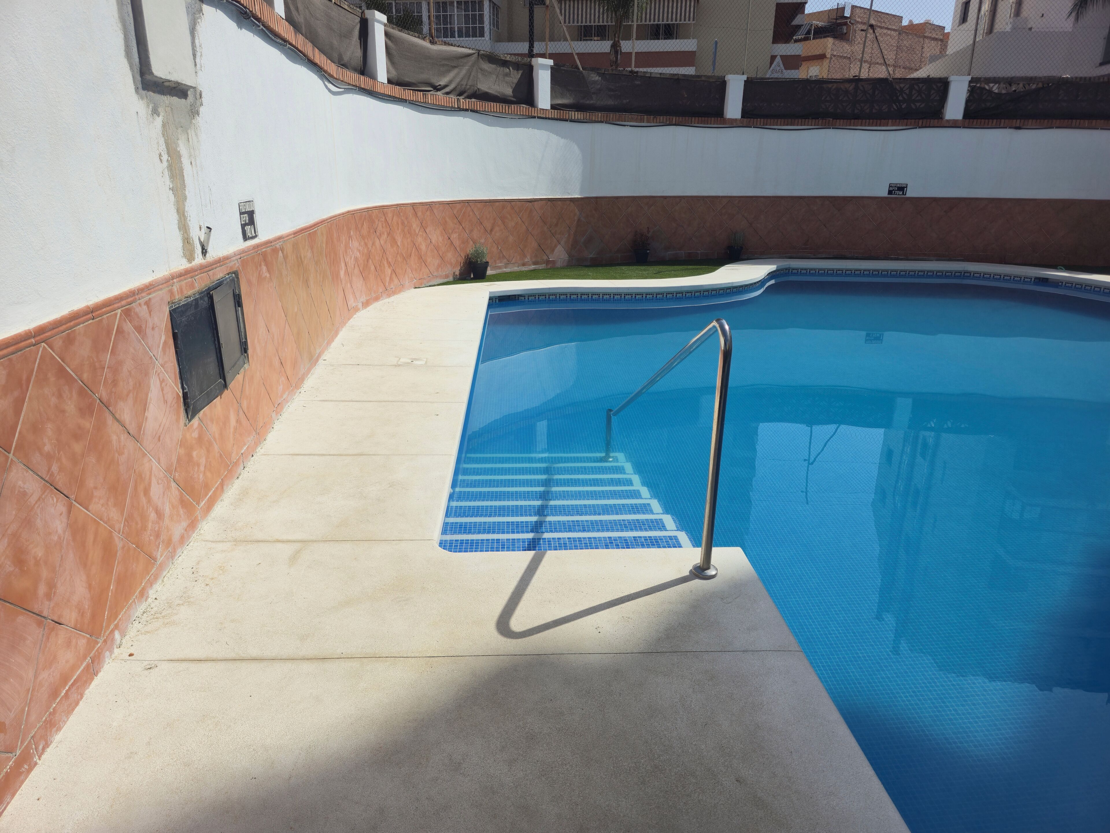 Une piscine avec une échelle et des marches en métal qui permettent d’y descendre.