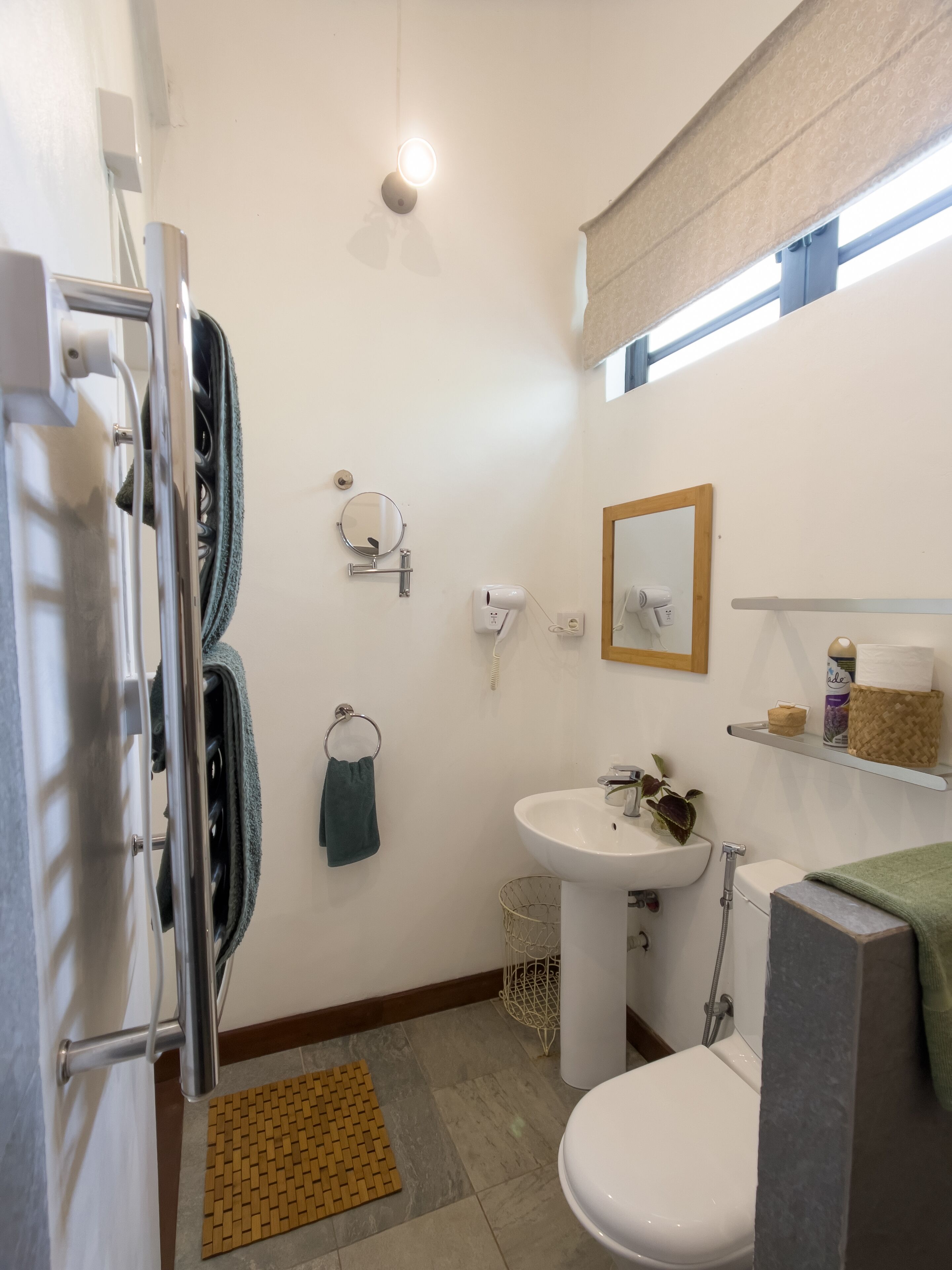 Uma casa de banho compacta com sanita, lavatório e chuveiro.