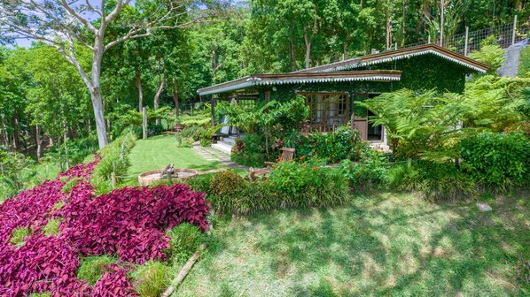 A traditional Japanese-style house surrounded by lush greenery and a well-maintained garden. - Green Cottage Chamarel (Chamarel)