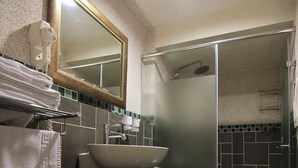 Ein modernes Badezimmer mit einem weißen Waschtisch, einem großen Spiegel, einem Waschbecken und einer Toilette.