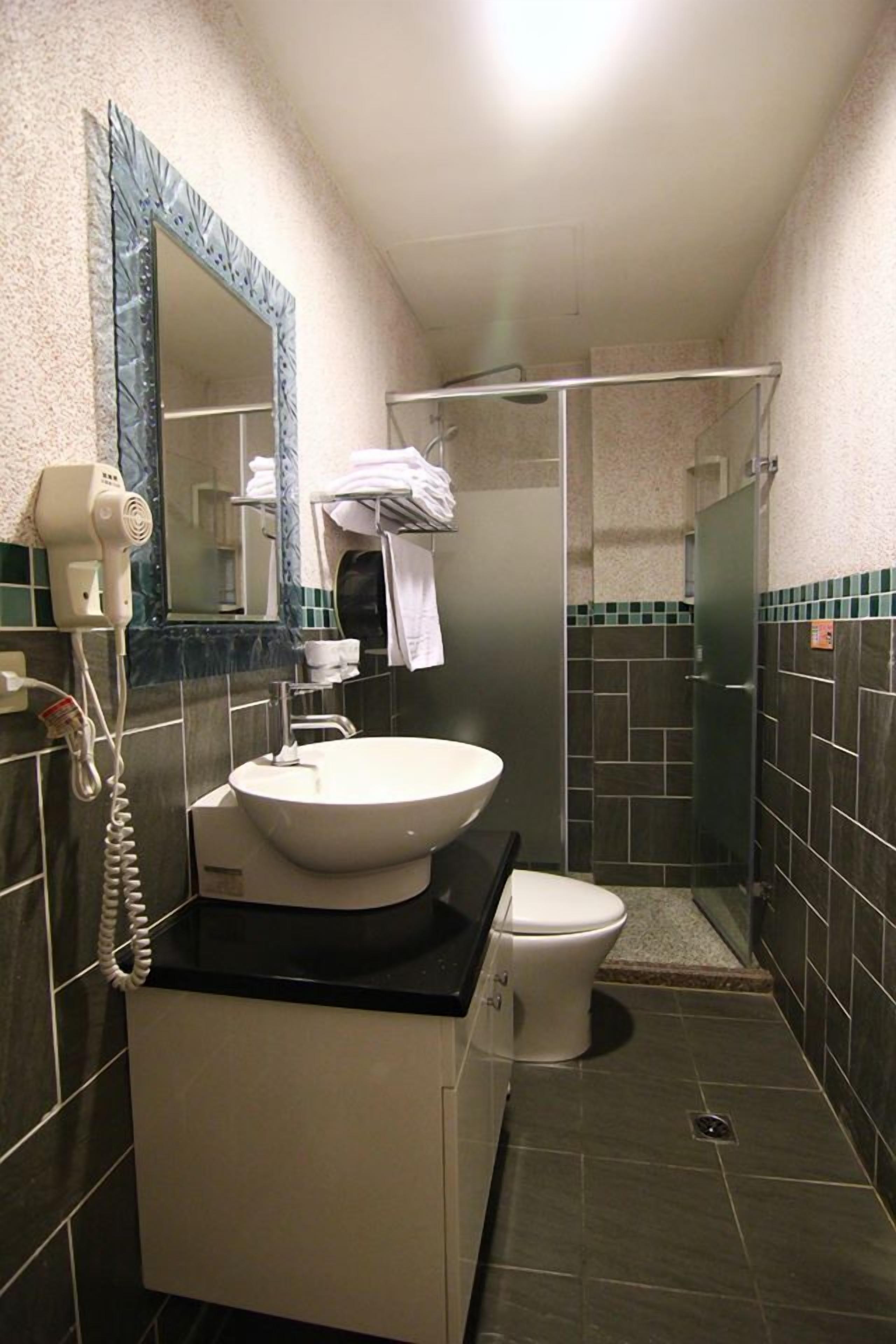 A small bathroom with a sink, toilet, and a hairdryer on a cabinet.