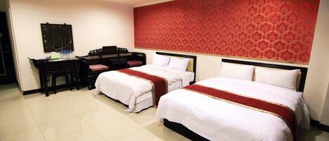 A hotel room with two beds, a desk, and a mirror.