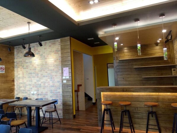 A modern interior with a brick wall, wooden accents, and a bar area with stools.