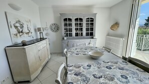 Classic design with a vintage flair, featuring a dresser, dining table, and large window with an outdoor view.