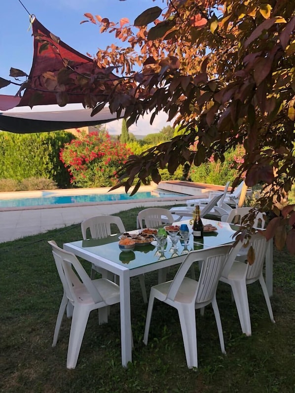 Enjoy al fresco dining in an outdoor setting with a pool view.
