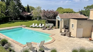 A swimming pool with lounge chairs and a patio area with a table and chairs. - Big house with pool house, large garden in a marvelous vacation city (L'isle-Sur-La-Sorgue)