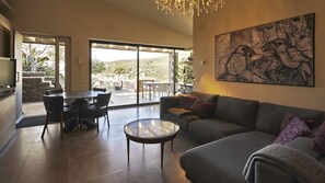 A spacious living area with a large sofa, a dining table with chairs, and a view through a glass door to an outdoor patio. - Apartment/ flat - Cadaques (Cadaques)