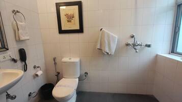 Ein Badezimmer mit Toilette, Waschbecken und einem gerahmten Bild an der Wand.