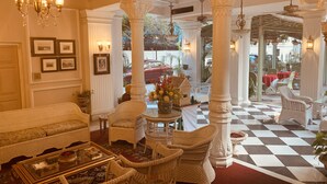 A lobby with wicker furniture, a checkered floor, and a view of the outside.
