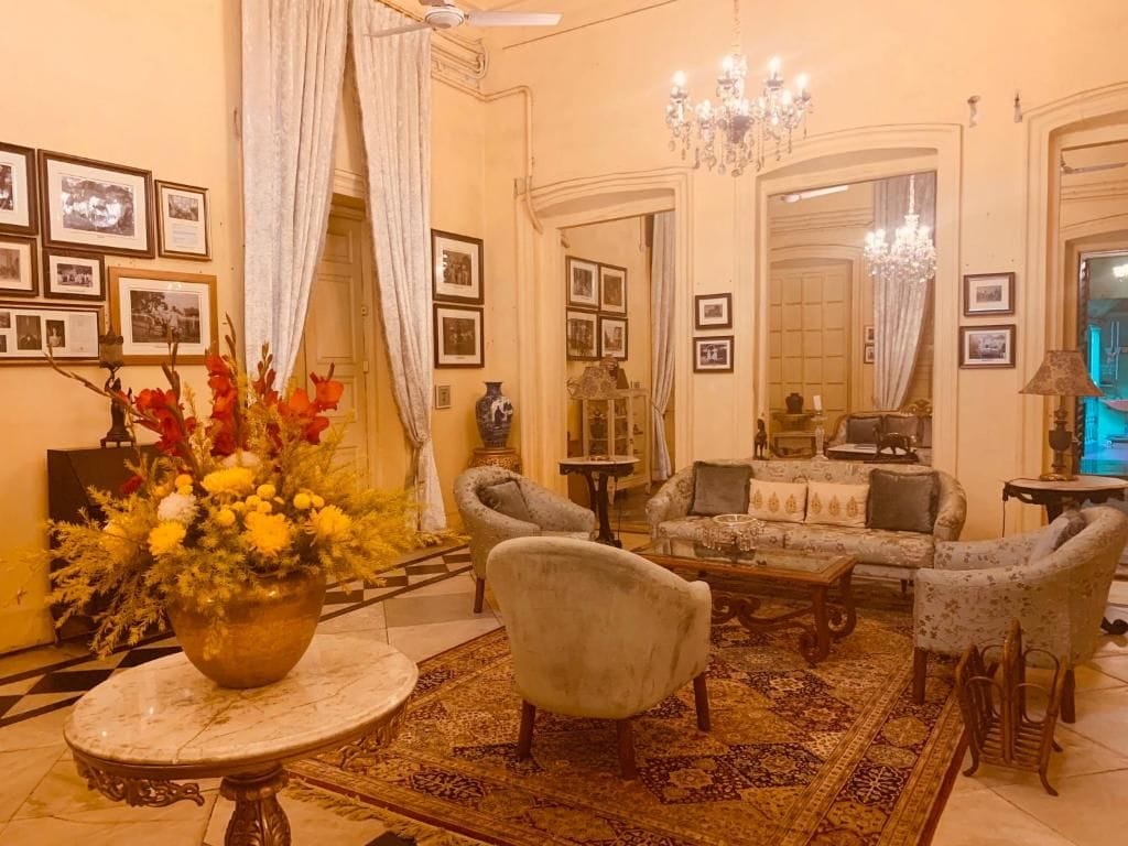 Una sala de estar tradicional con un conjunto de sofá, sillones, una mesa de centro y una araña.