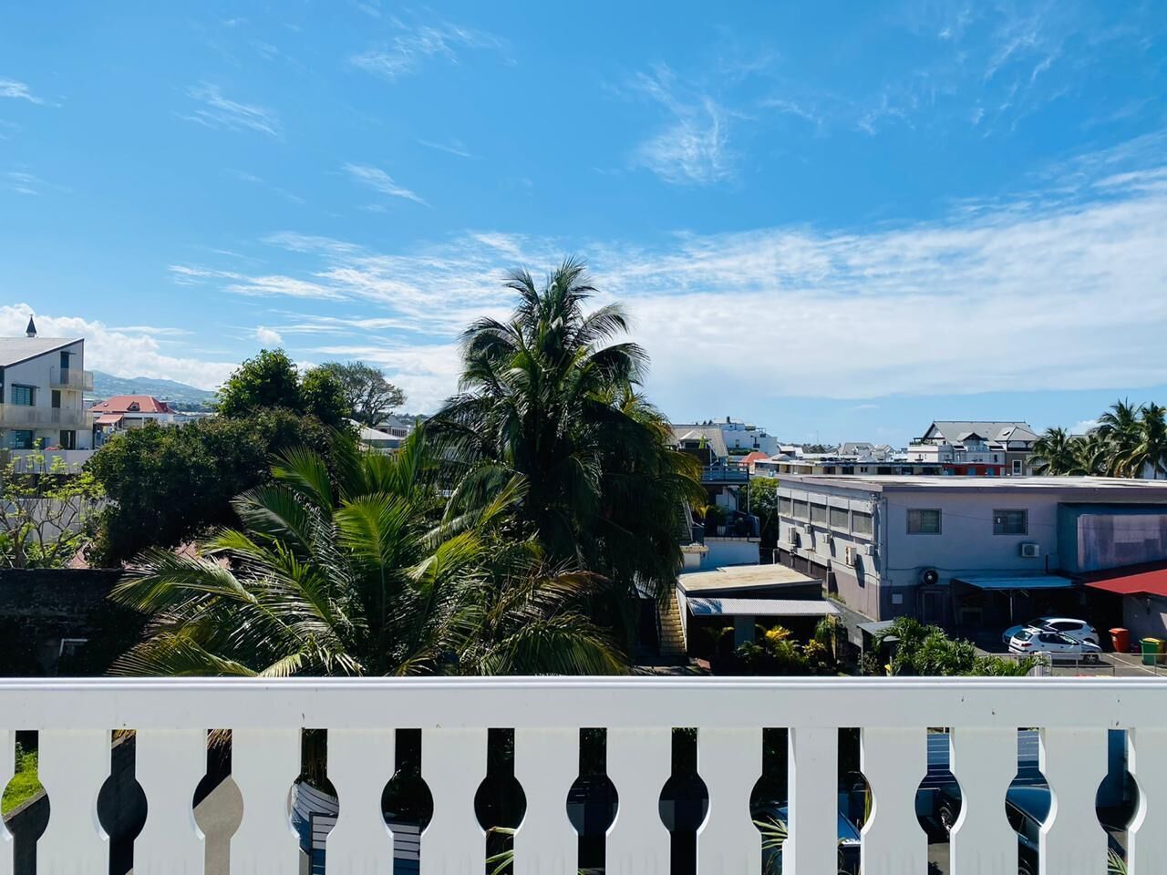 Un paisaje urbano costero con edificios, palmeras y cielo despejado.