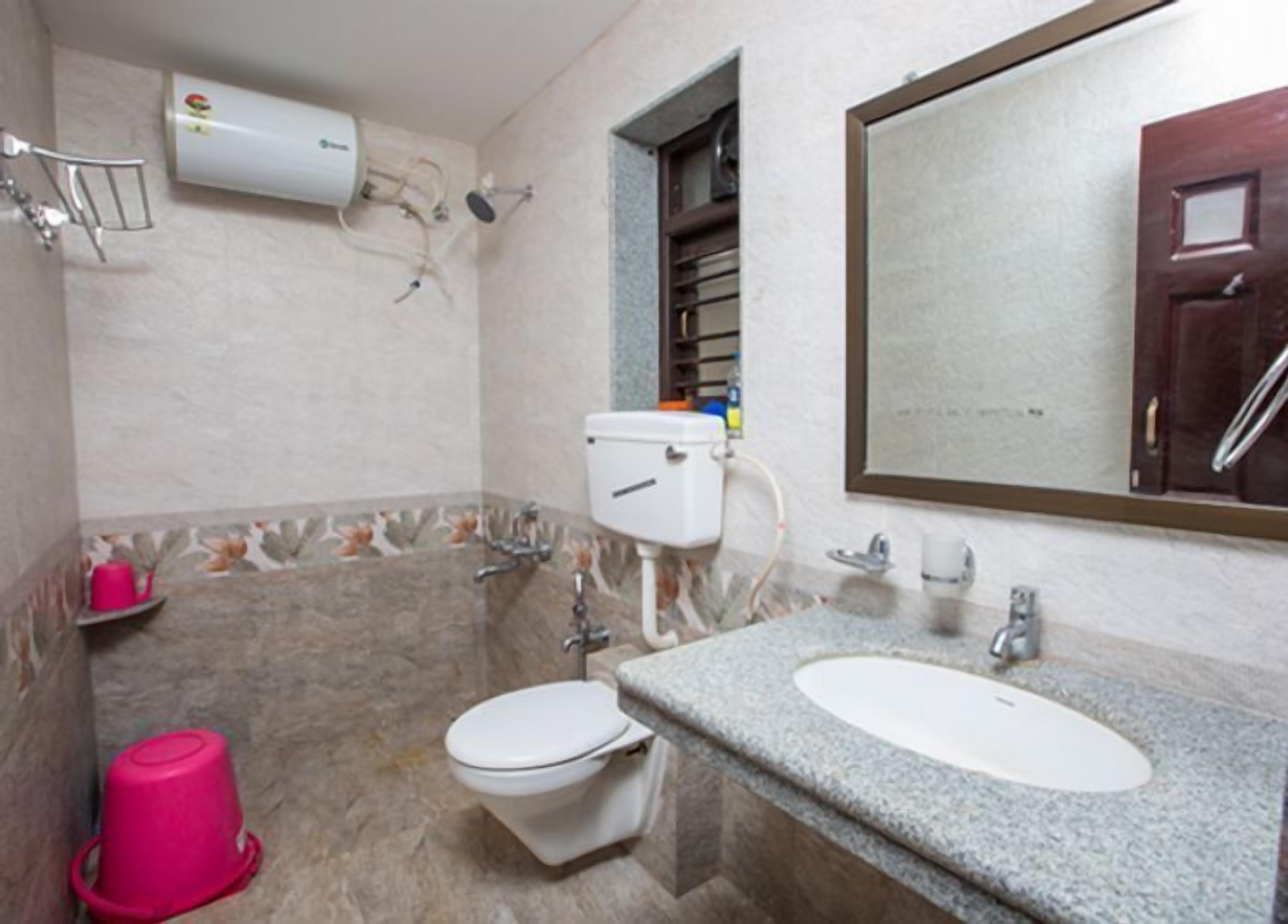 Une salle de bain équipée de toilettes, d’un bidet et d’un lavabo.