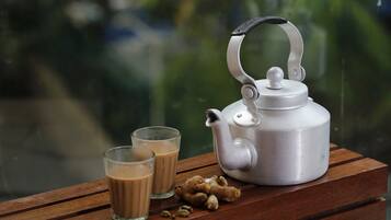 A silver teapot with a handle on a wooden table.