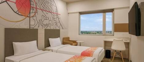 A hotel room with two beds, a desk, a chair, a TV, and a window with a view.