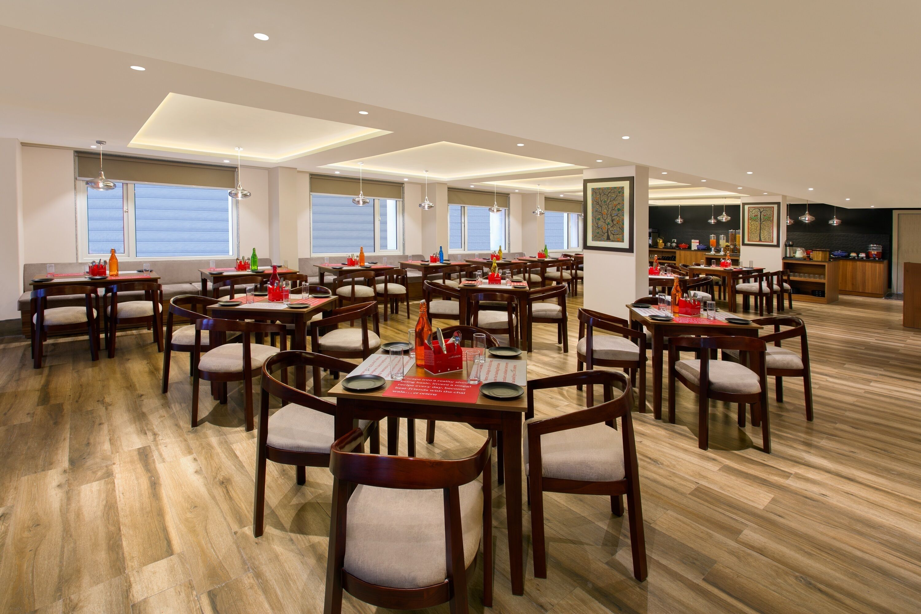 Un'ampia sala da pranzo con diversi tavoli e sedie in legno, ampie finestre e un moderno design del soffitto.