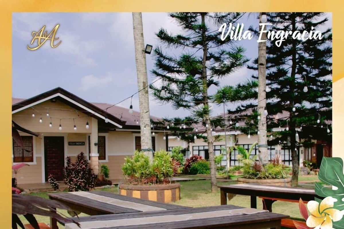 A villa with outdoor seating and a garden.