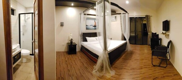 Un dormitorio con cama con dosel, mesita de noche, una silla y televisor.