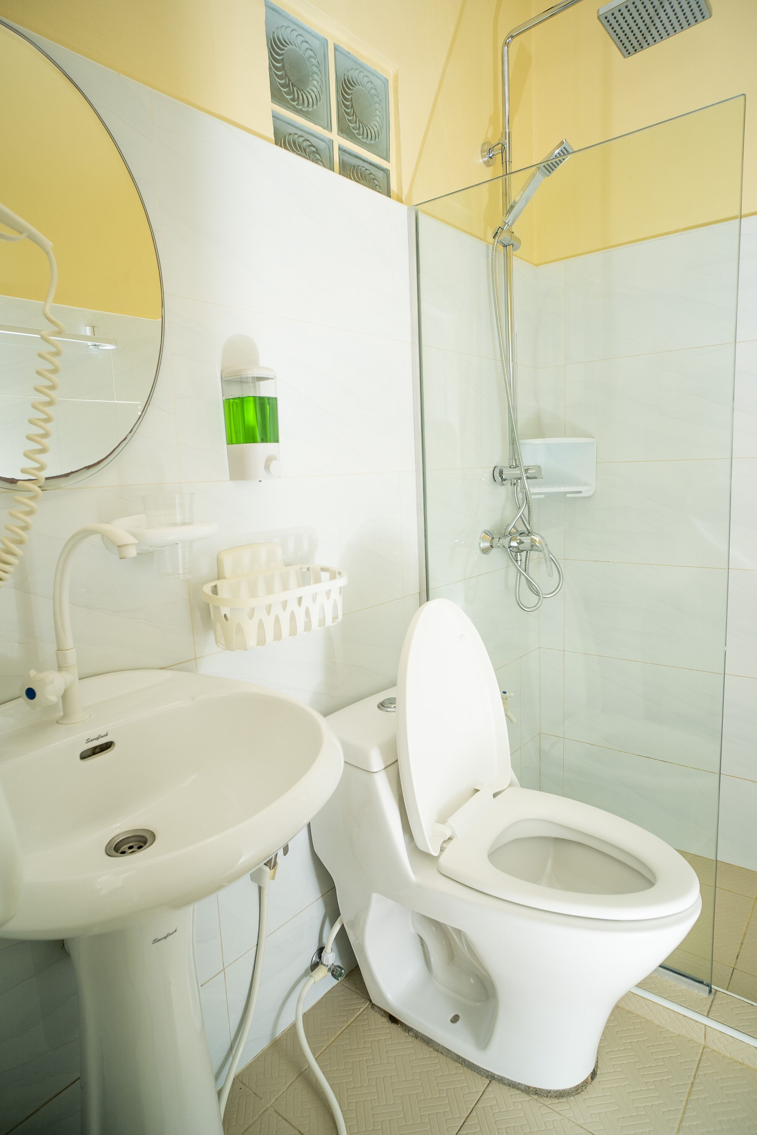 Un baño moderno con inodoro, lavamanos y ducha.