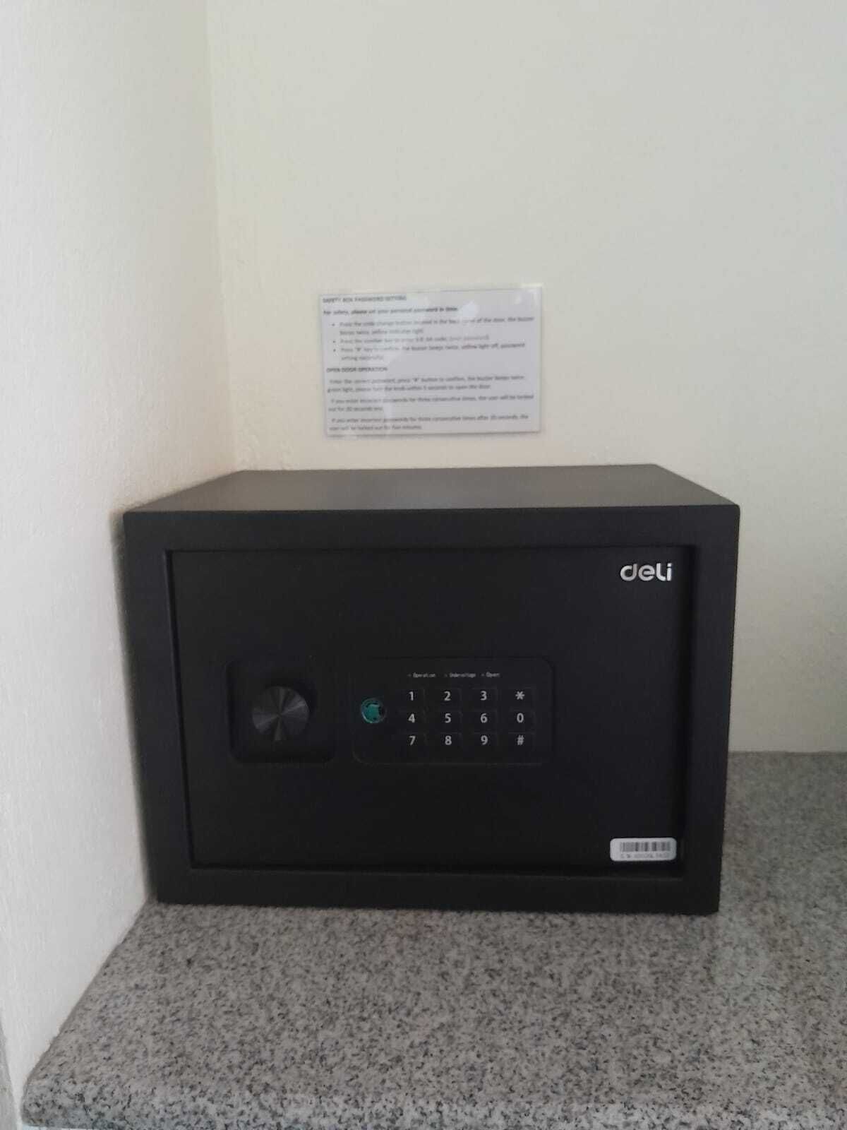 A black safe with a keypad and a small window, placed on a granite countertop.
