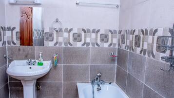 A bathroom with a sink, mirror, and bathtub.