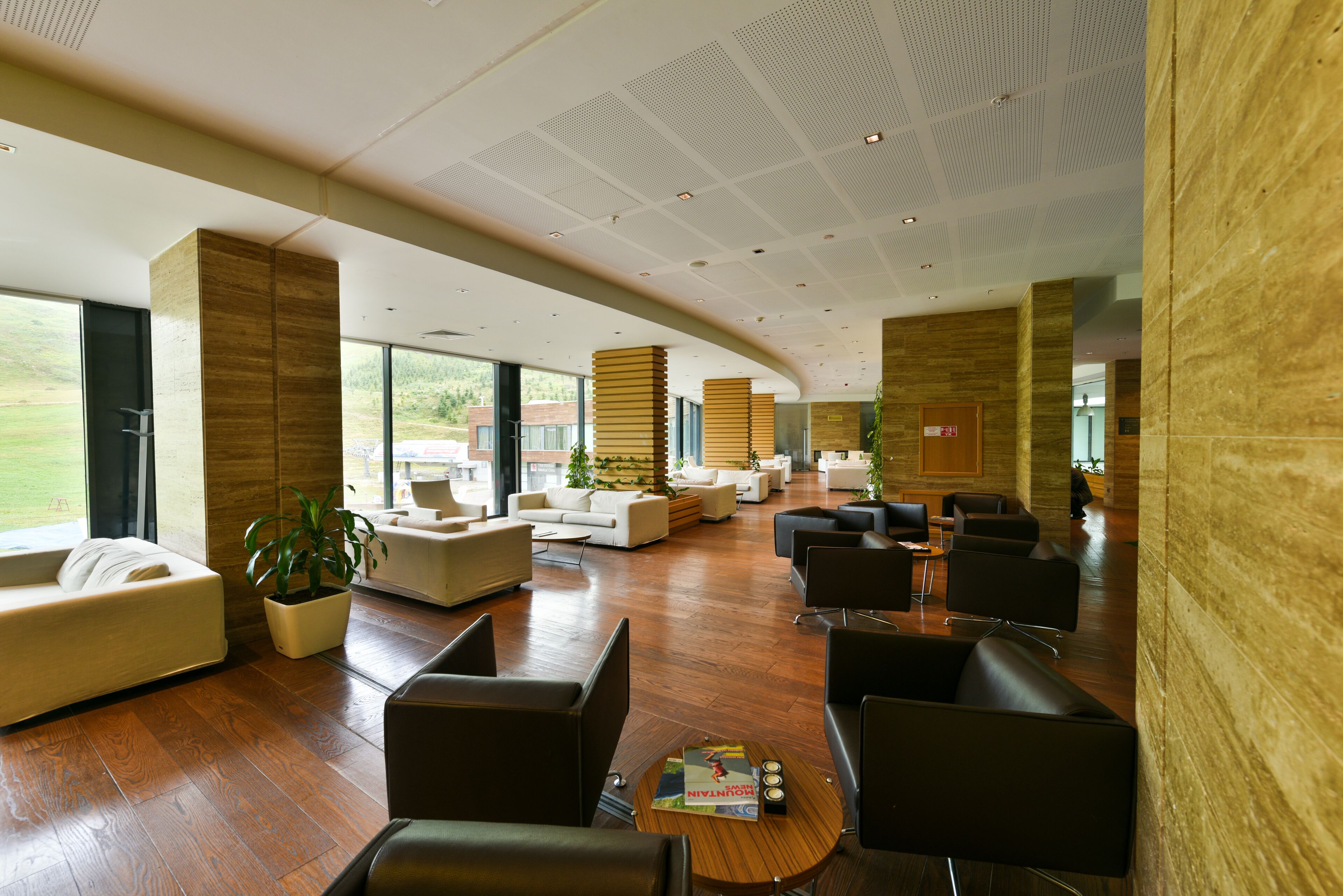 Un hall d’entrée spacieux, doté de meubles modernes, de grandes fenêtres et d’un plancher en bois.