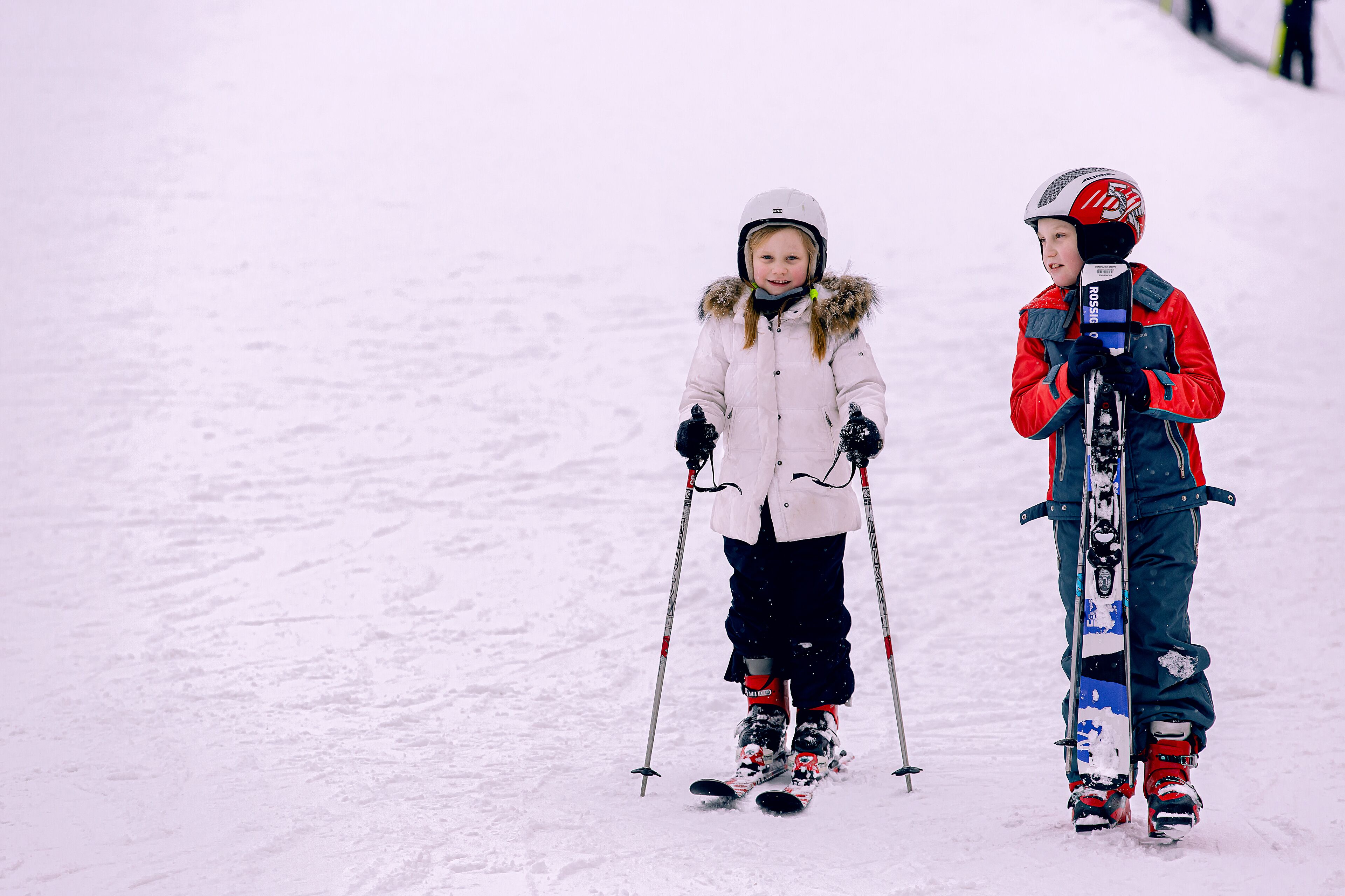 Due bambini sciano su un pendio innevato.