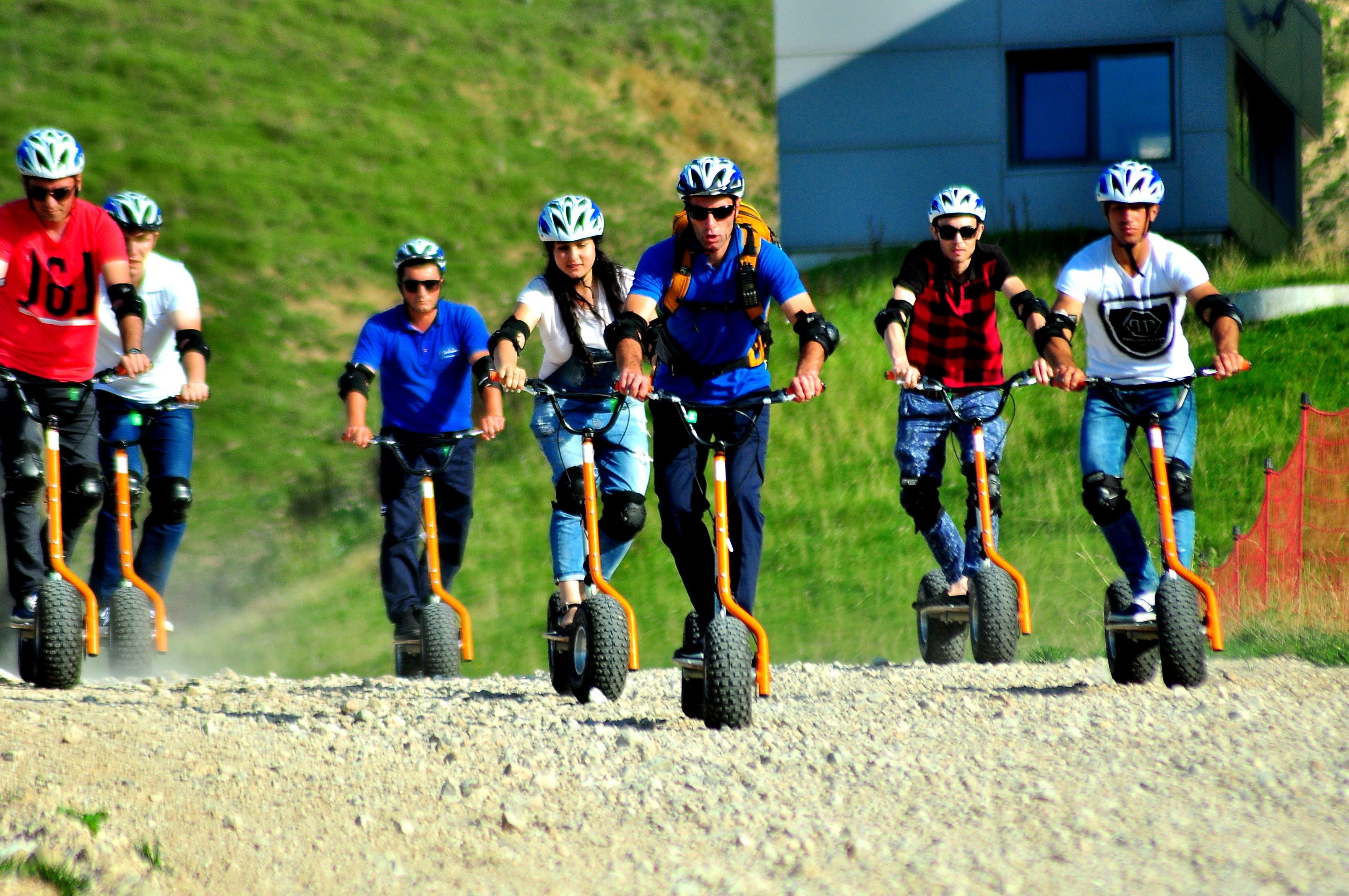 Eine Gruppe von Menschen fährt mit Elektrofahrrädern auf einem Schotterweg.