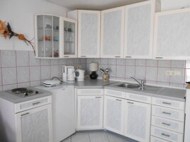 Apartamento superior, terraza, mirando al mar (Crveni) | Cocina privada | Frigorífico, placa de cocina, hervidor eléctrico y tostadora