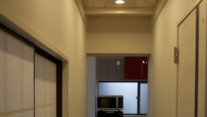 En smal hall med ett träpanelat tak och en mikrovågsugn synlig i bakgrunden.