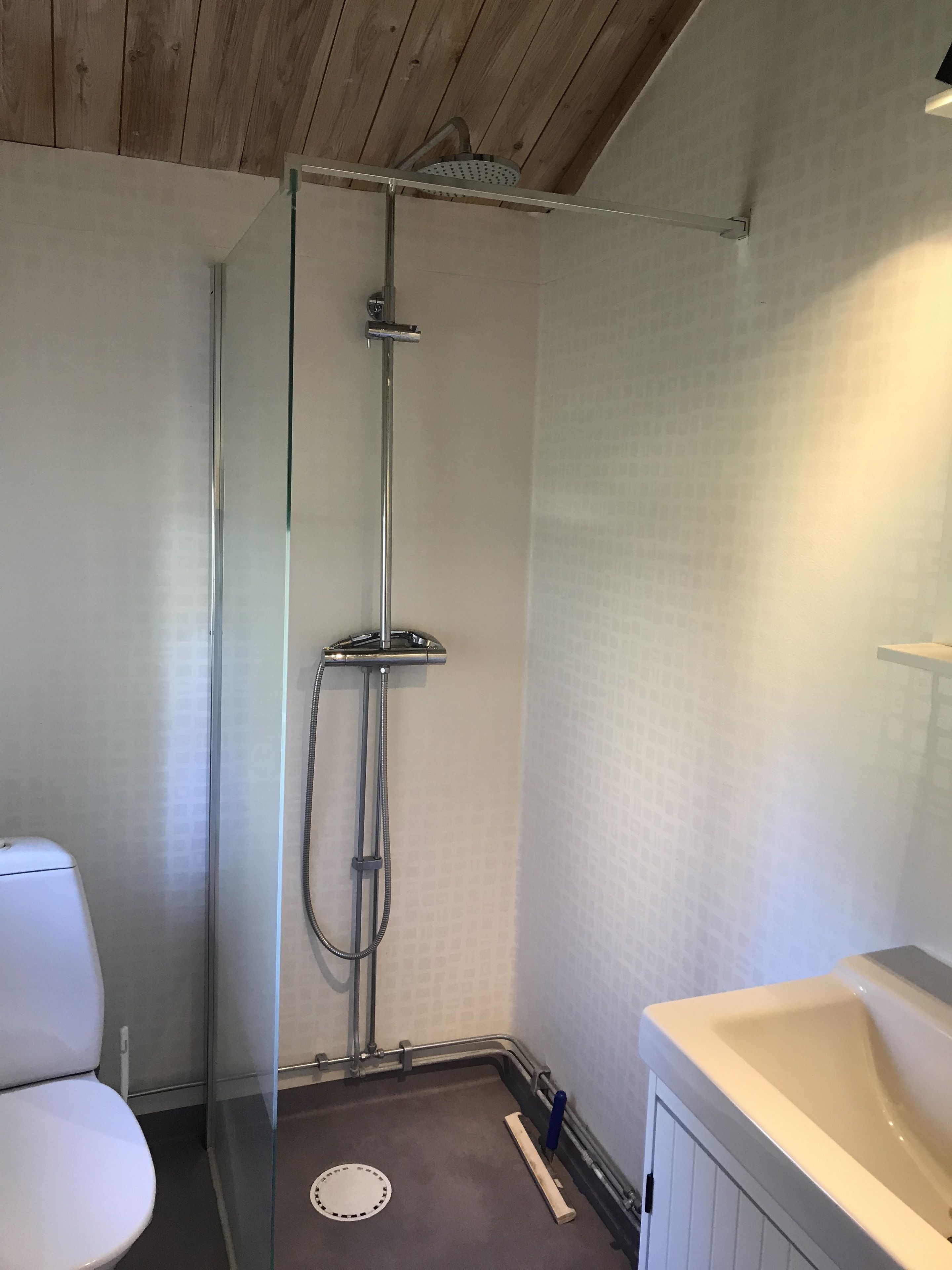 A bathroom with a shower, toilet, and sink.