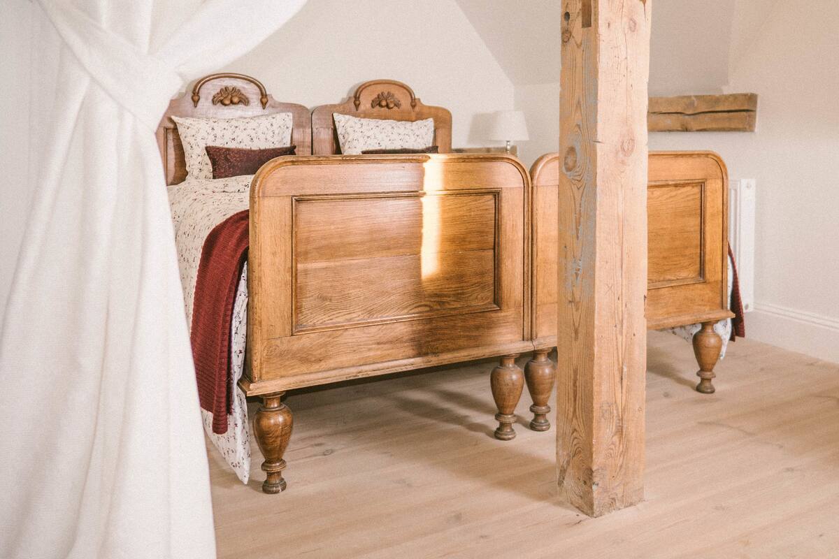 Un dormitorio con cama y cabecera de madera, y dosel blanco.