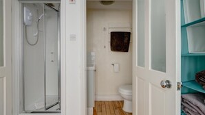 A bathroom with a shower, toilet, and a towel rack.