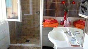 A bathroom with a glass shower enclosure, a white sink, and a mirror above it. - B&B Chez Rose-Marie (Vaison-la-Romaine)