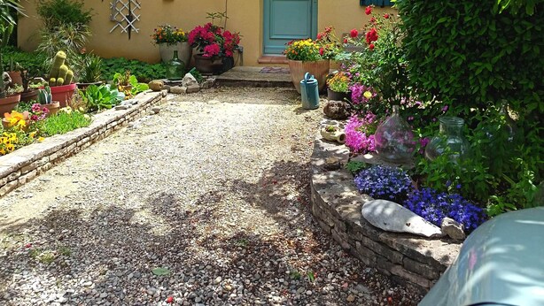A house with a gravel driveway, potted plants, and a blue door. - B&B Chez Rose-Marie (Vaison-la-Romaine)