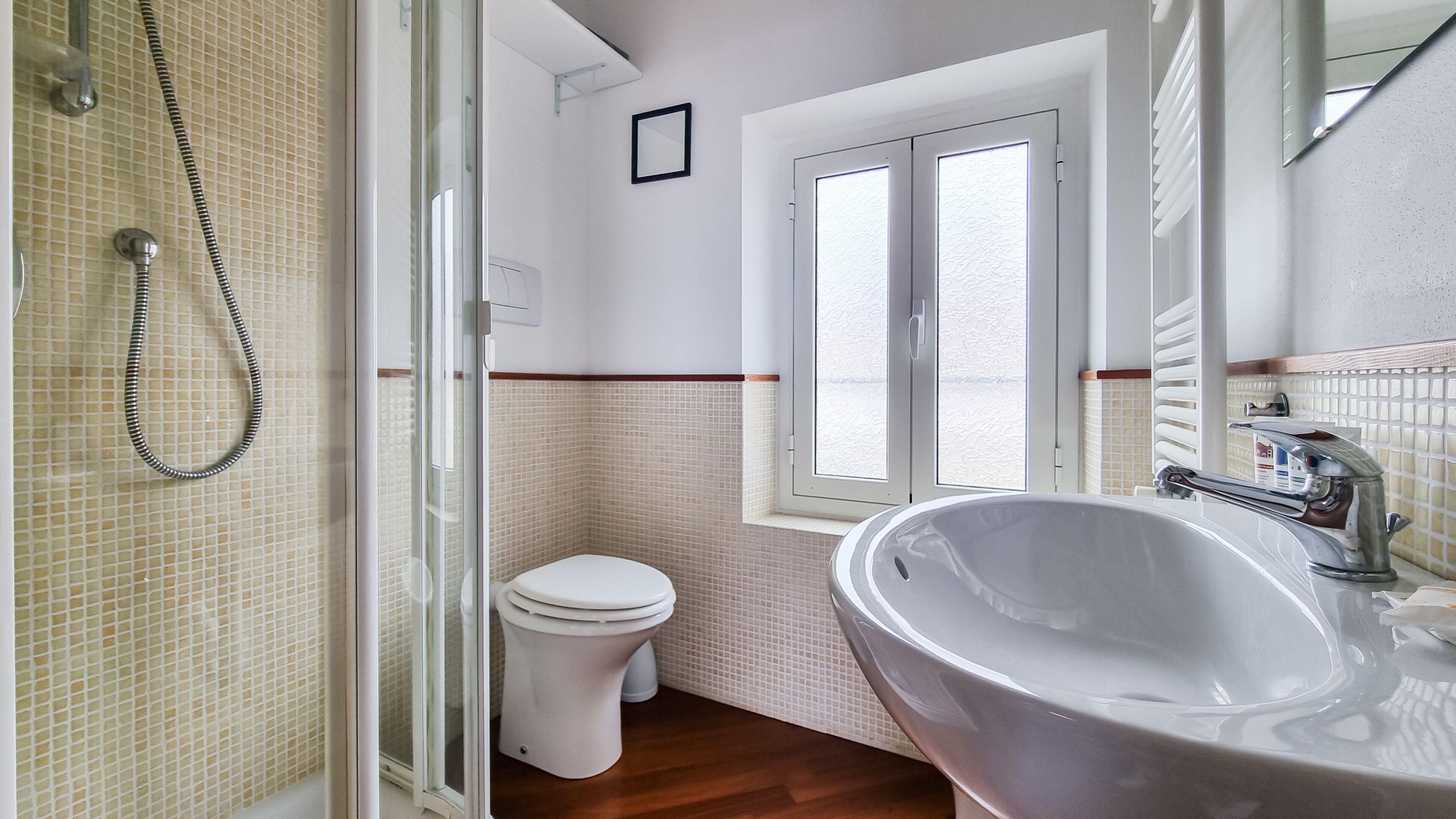 A bathroom with a shower, toilet, and sink.