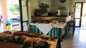 Een buffetopstelling met verschillende gebakjes en een keuken op de achtergrond.