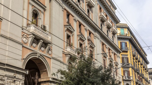 Un edificio de varios pisos con características arquitectónicas clásicas, incluyendo balcones ornamentados y molduras detalladas.