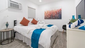 Une chambre d’hôtel équipée d’un lit, d’un bureau, d’une chaise, d’une lampe, d’un tableau et d’un climatiseur.