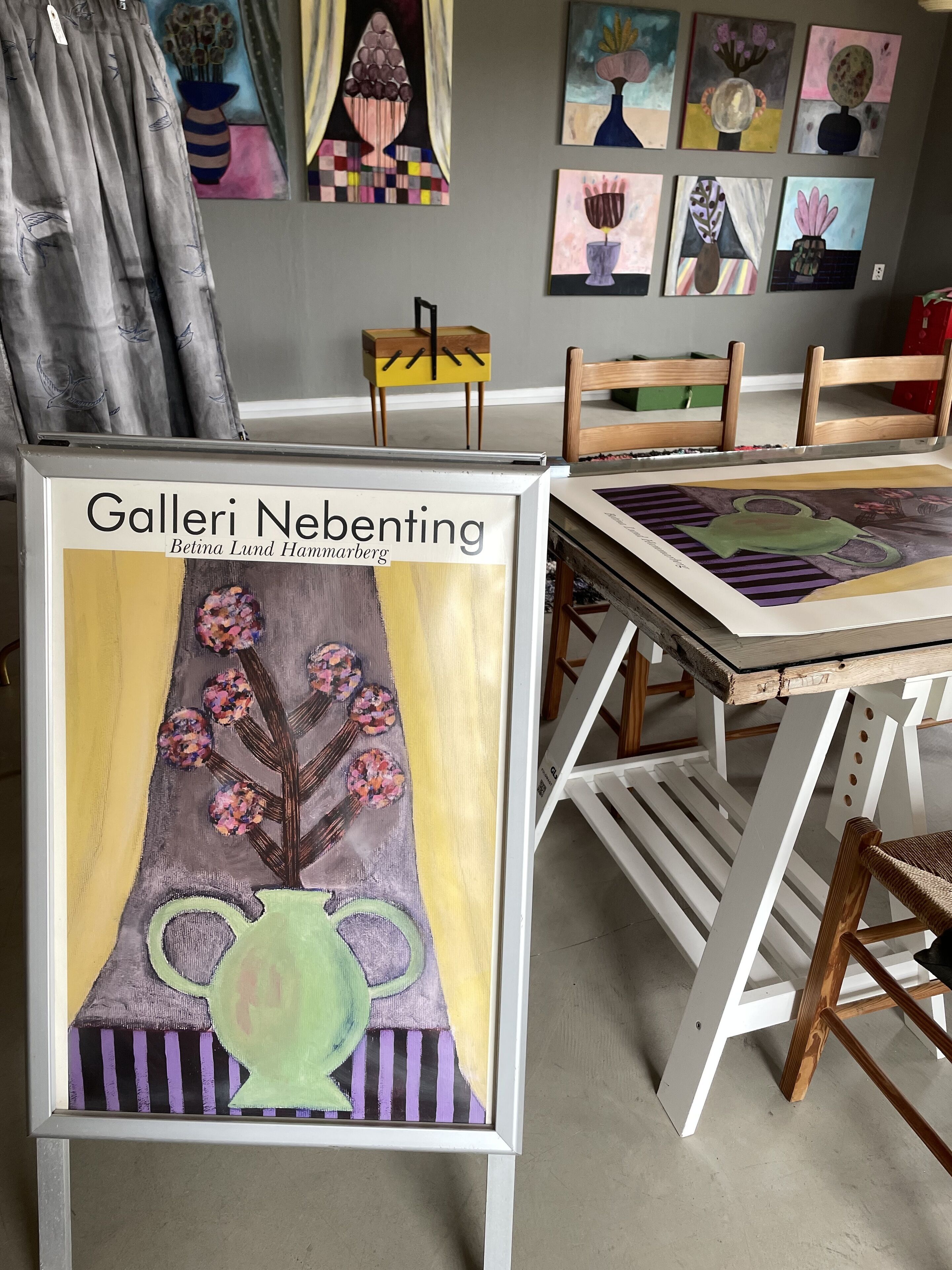 Una obra de arte enmarcada titulada 'Galeri Nebenting' de Betina Lund Hammarberg, que muestra un jarrón con flores.