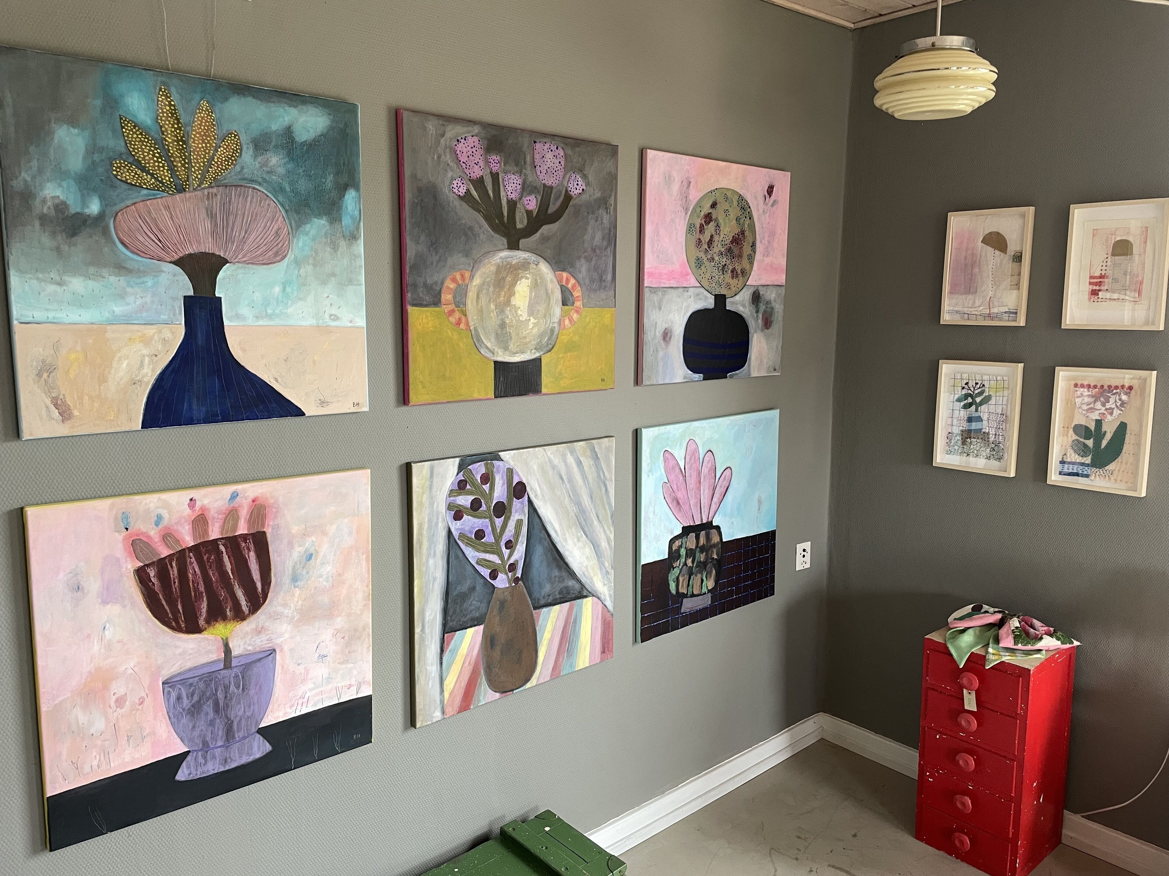 A gallery wall with various abstract paintings.