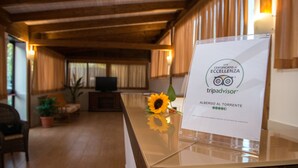 Un comptoir d’accueil orné d’un certificat d’excellence TripAdvisor, d’un tournesol et doté d’un décor intérieur en bois.